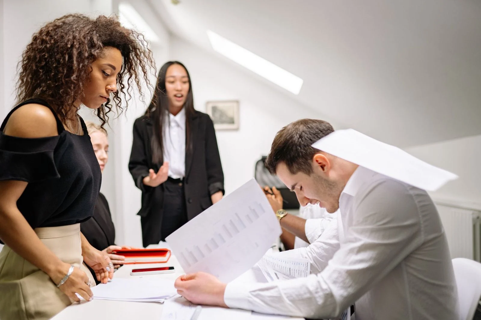 A diverse group of business professionals discussing and collaborating around a table in a modern office.