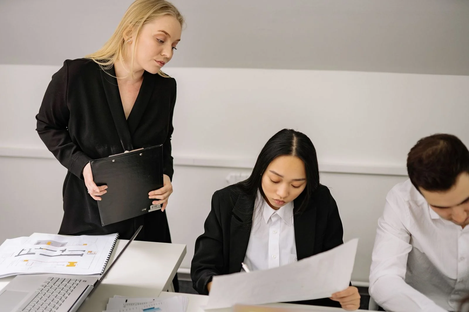 A diverse group of professionals discussing business matters around a table in an office meeting.