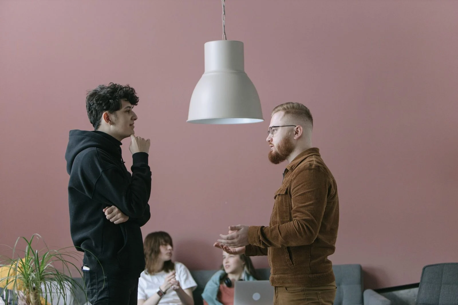 A group of young professionals talks casually during a meeting in a modern, stylish office.