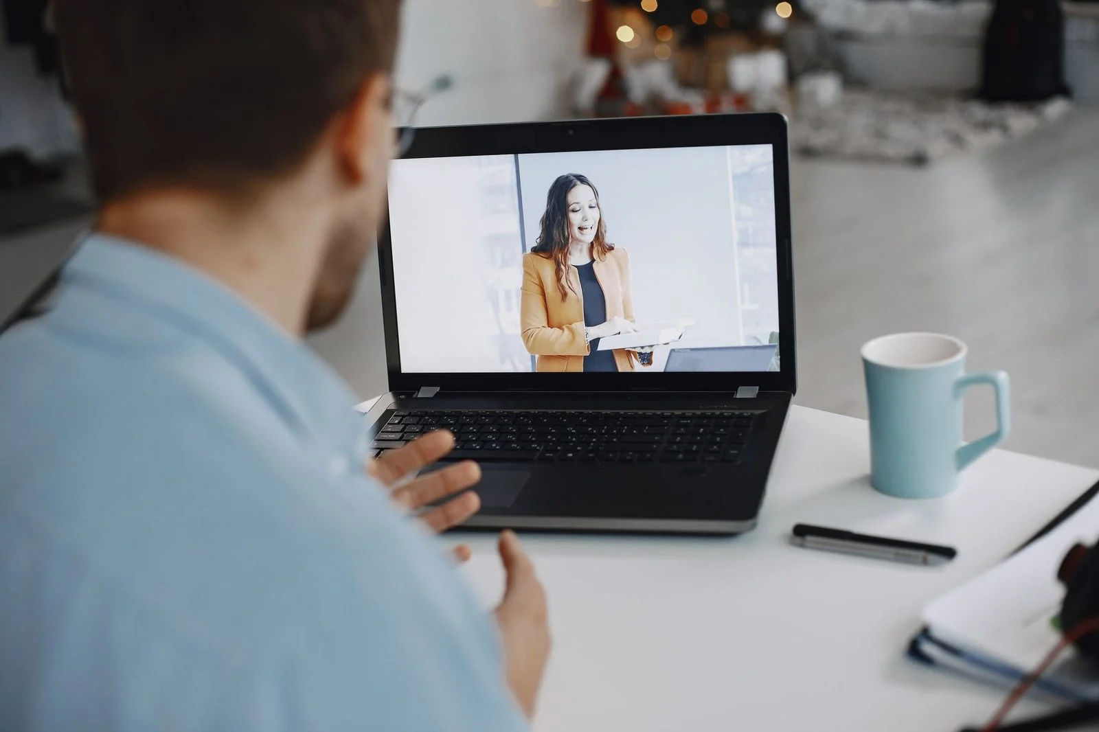 A man on a laptop video call with a colleague while working at home.