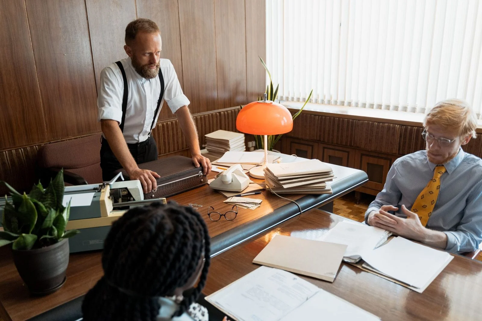Business meeting in a retro-styled office, with vintage decor and people in classic attire.