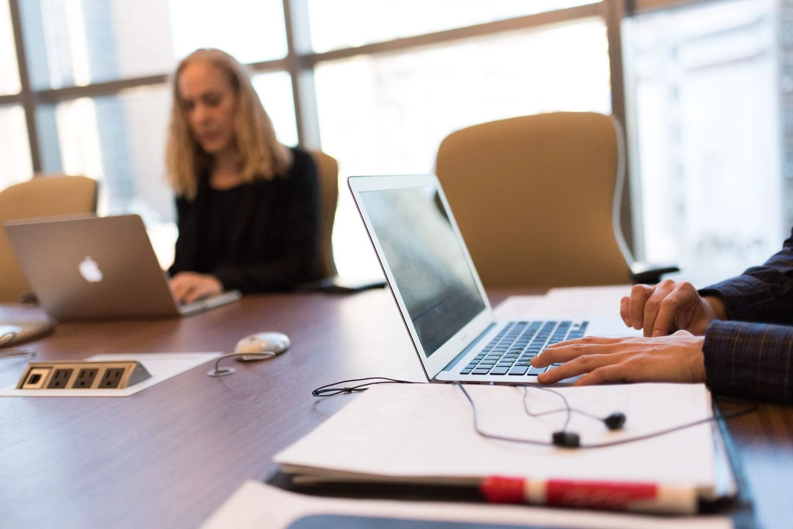 Colleagues collaborate at a laptop in a bright, modern office.