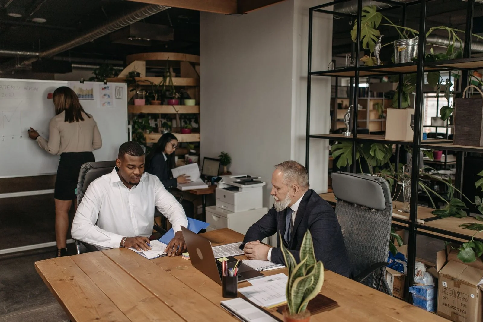 Diverse business team meets around a table in a modern office.
