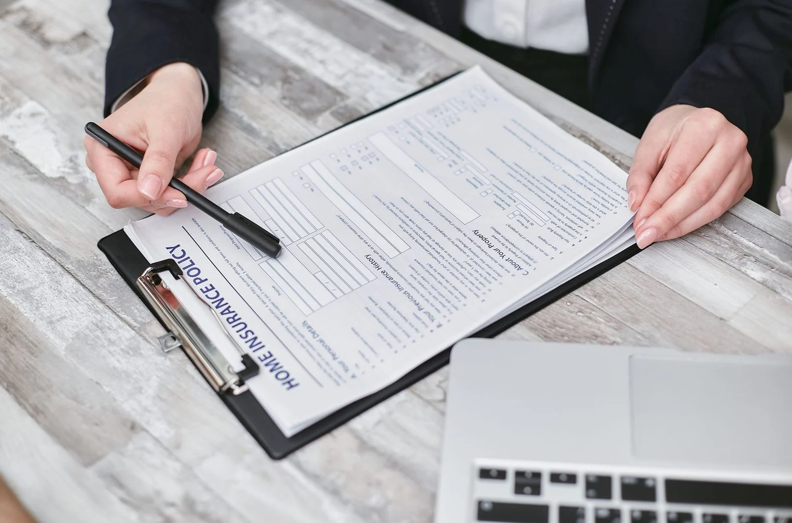 Hands reviewing a printed insurance policy document with a pen, representing professional life insurance planning.