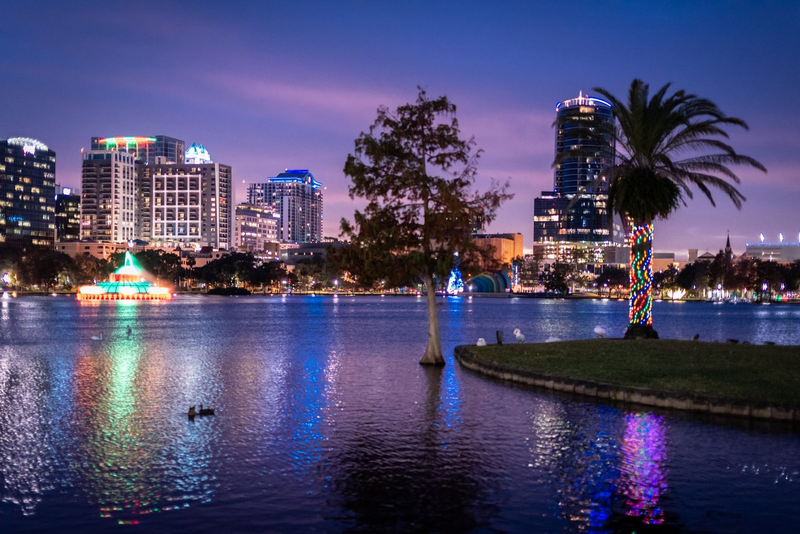 Horizonte vibrante de Orlando reflejado en el lago Eola al atardecer.