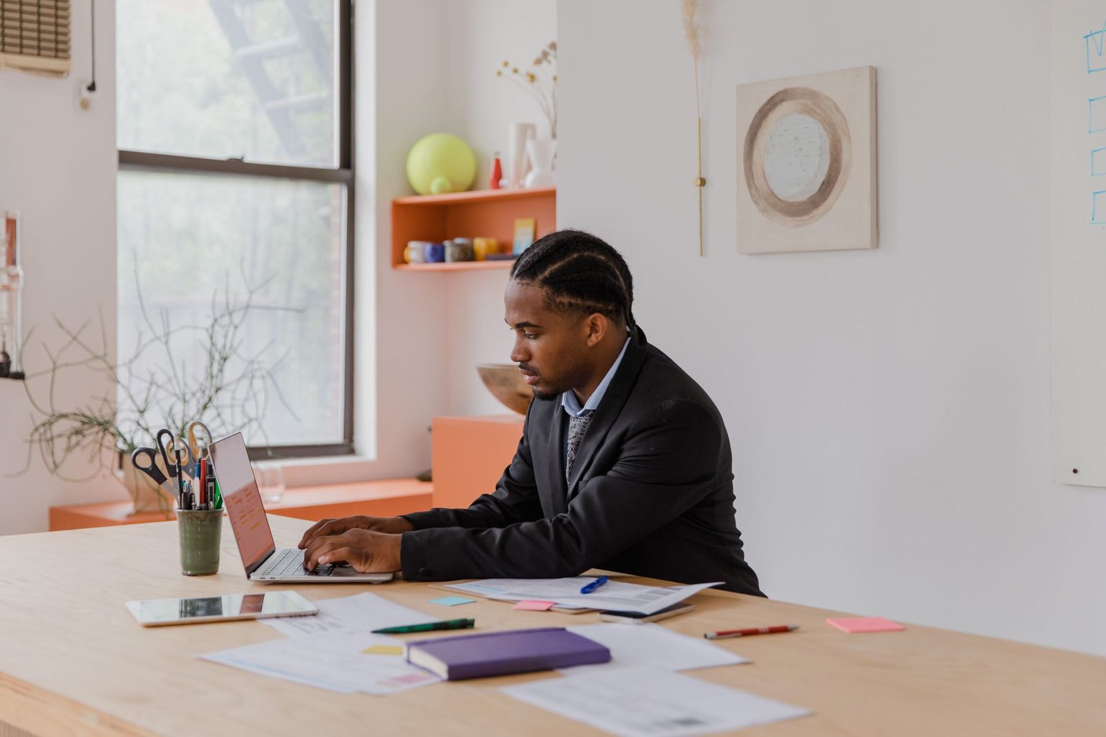 Indian-American businessman working on laptop at office desk.
