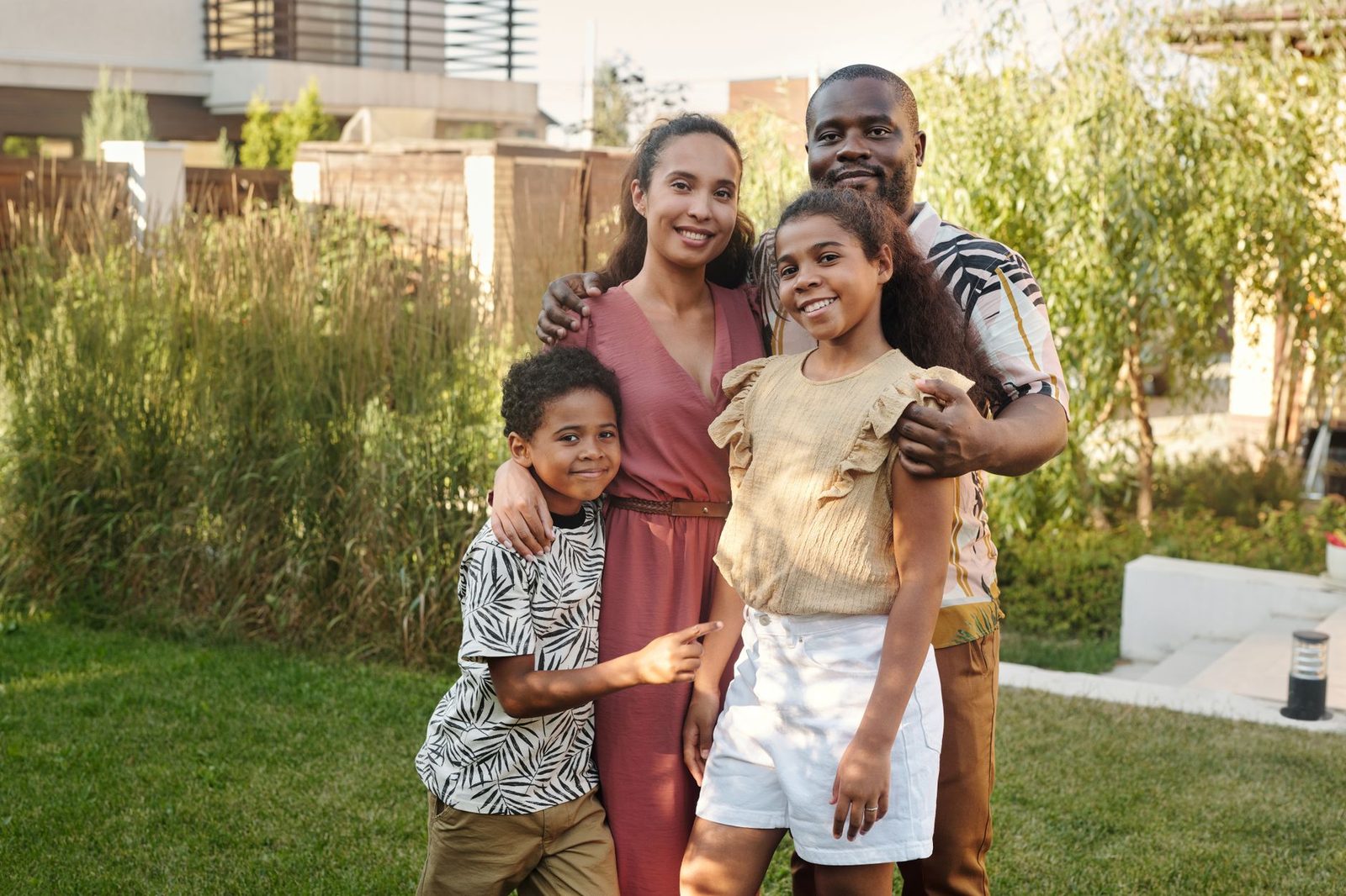 Multicultural family smiling together outdoors in sunny garden.