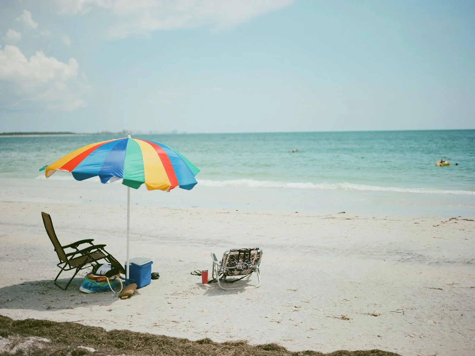 Sombrillas de colores y tumbonas en una playa de Clearwater, Florida, con el mar al fondo.