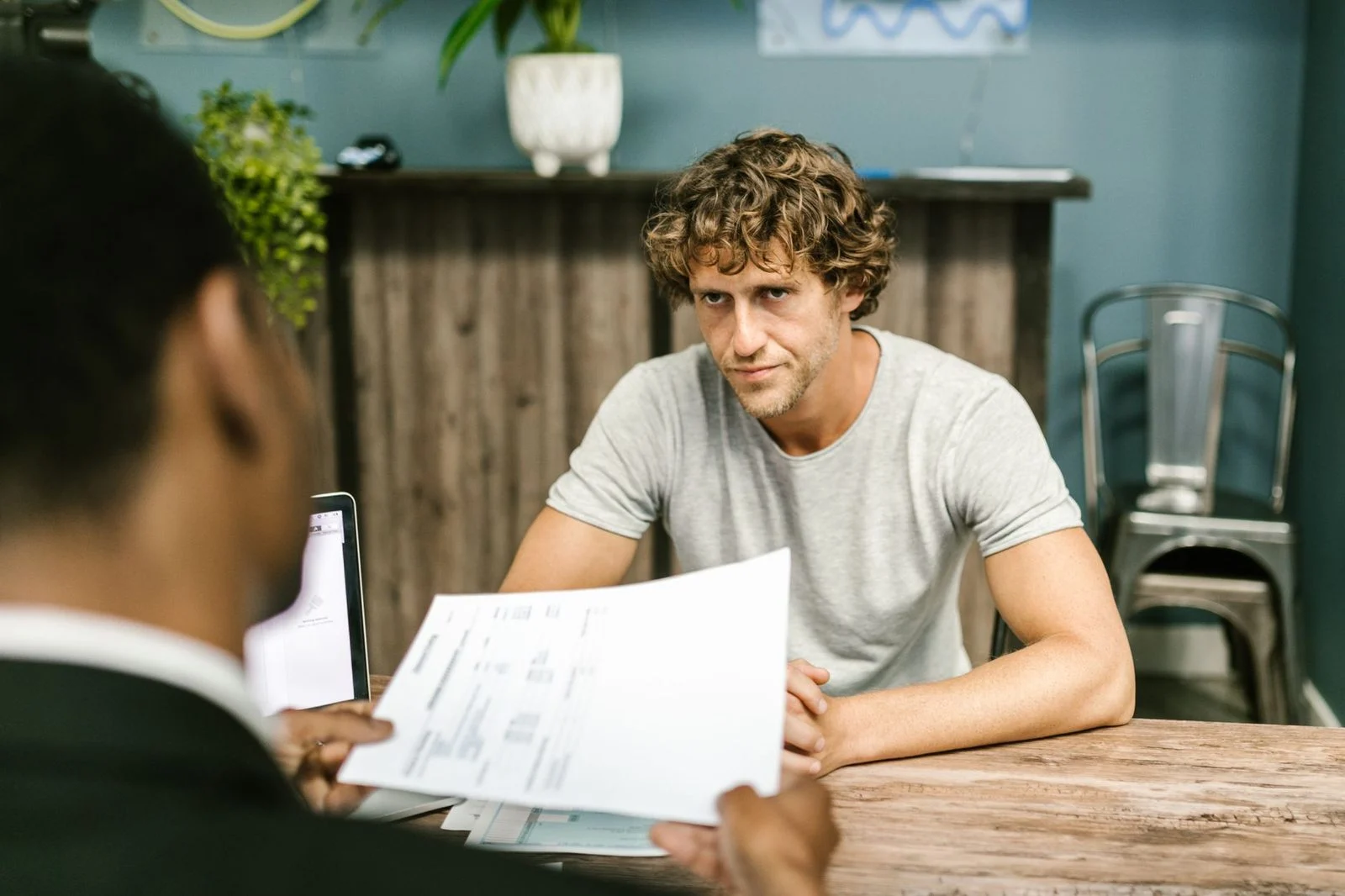 Two men in a contemporary office review documents together during a business meeting.