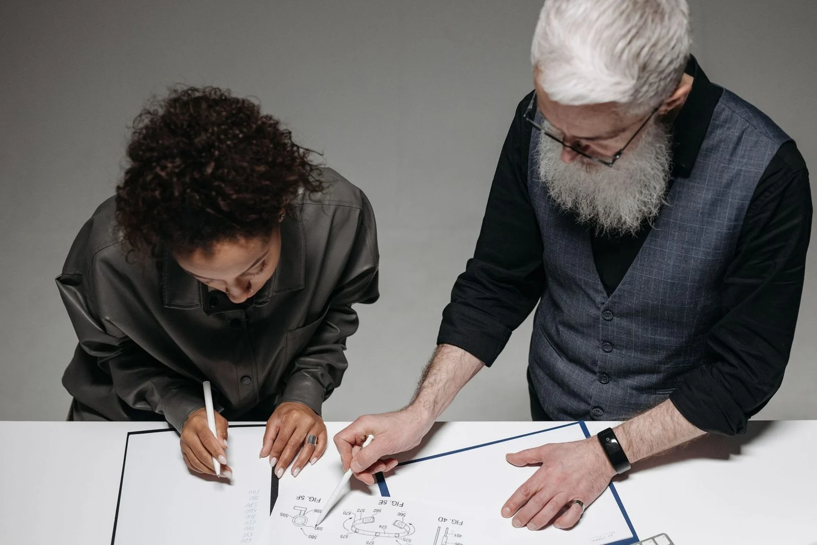 Two professionals collaborate over a design project in a bright, modern studio.